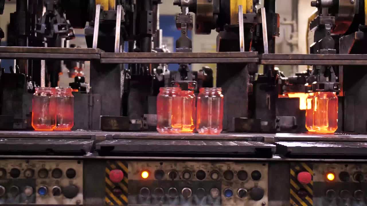 Hot glass containers moving through a forming line